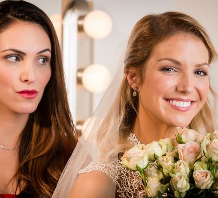 0 Suspicious bridesmaid standing behind smiling bride