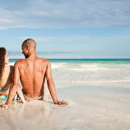 young couple beach ocean travel vacation fun luxury