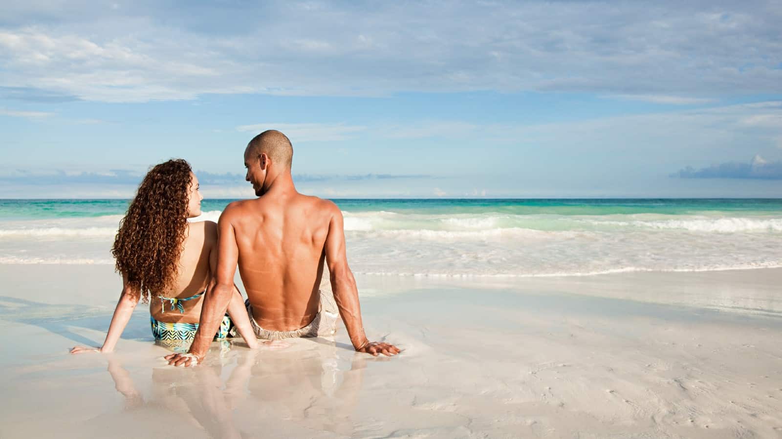 young couple beach ocean travel vacation fun